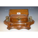 An oak Arts & Crafts desk stand with recessed pen tray,