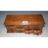 An early 20th century oak watchmaker's chest, hinged oversailing top with moulded edge,