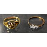 An 18ct gold and platinum three stone diamond ring; an 18ct gold cross over flower ring (2) (3.