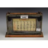 An E.P.N.S mounted oak perpetual desk calendar, beaded border, 21cm wide, c.