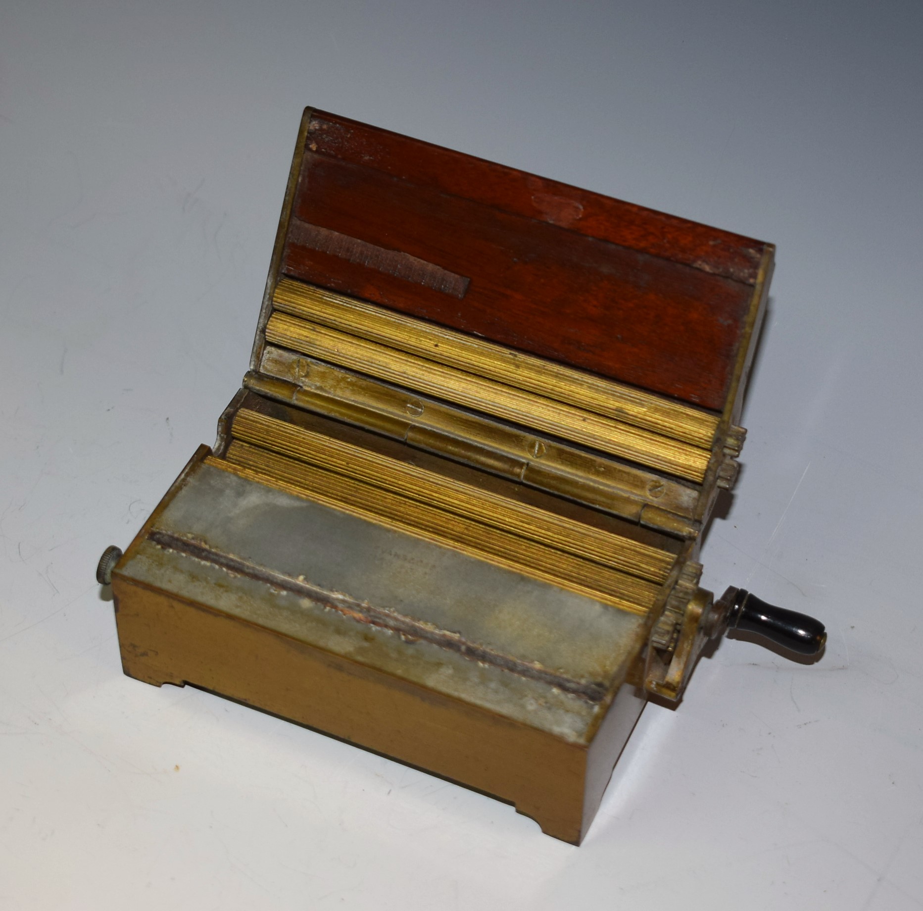 An early 20th century Evans & Co patent mahogany and brass cigarette making machine, hinged cover,