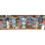 A set of eight cast iron campana garden urns, circular bodies, ornate cast rims and feet,