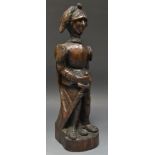 A North European oak carving, of a knight, he stands, in armour, his sword and shield at his side,