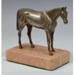 A silver coloured metal model of a race horse, rose marble plinth,