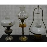 A brass oil ceiling lantern; a oil lamp with amber glass reservoir; another.
