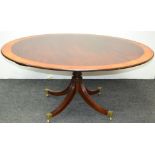 A reproduction mahogany circular single pedestal tilt top dining table