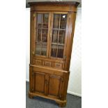 An oak floor standing corner cupboard by Lion House Furniture