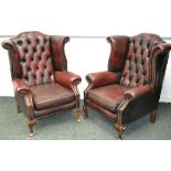 A pair of leather wingback armchairs,