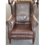 A modern brown leather wingback armchair