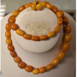 Jewellery - a graduated single strand of amber coloured oval beads and pair of similar circular
