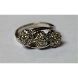 A diamond triple head cluster ring, each floral head inset with seven round brilliant cut diamonds,