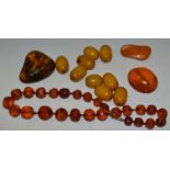 Nine butterscotch amber beads; a polished amber stone;