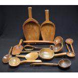 Treen - a 19th century elm grain scoop, 43cm long; others; ladles; spoons; etc,