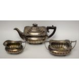 A George V silver three piece half fluted boat shaped tea service, comprising teapot,