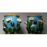 A pair of Continental Majolica jardinieres, each decorated in relief with lilys and swallows,