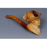 A 19th century Meerschaum pipe, the bowl as lady of fashion's head, amber-coloured mouthpiece,