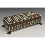 A 19th century Anglo-Indian Sadeli marquetry rectangular games box, hinged cover inlaid for chess,