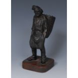 A 19th century French dark patinated spill holder, cast as a grape picker, he stands,