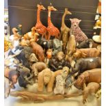 Carved wooden African animals and birds, some painted, including giraffes, zebra, elephants, rhinos,