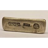 A Chinese silver coloured metal bar ingot, cast seal stamps, 81mm long,