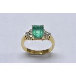 A baguette emerald and diamond cluster ring, central rectangular baguette emerald, measuring 8.