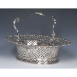 A fine George II Rococo silver shaped oval swing-handled cake basket,