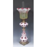 A 19th century Bohemian opaque overlaid cranberry glass table oil lamp, frilled vaseline shade,