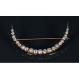 A diamond and cultured pearl crescent brooch, arched body,