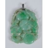 A diamond mounted carved green stone possibly jade pendant,