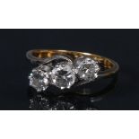 A diamond trilogy ring, twisting linear set with three round brilliant cut diamonds,