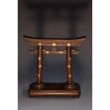 A Japanese dark patinated pocket watch stand, as a gateway, decorated overall with gilt mon,