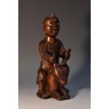 A 19th century Chinese hardwood carving, of a boy riding a mule, inset bone eyes and teeth,