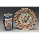 A Japanese shaped circular Imari charger, decorated with flowers in a basket,