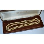 A pearl necklace with opal and pearl clasp