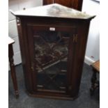 A George III oak corner cabinet, canted front, astragal glazed door,