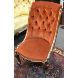 A Victorian nursing chair burnt ochre button backed upholstery, shaped and carved legs,