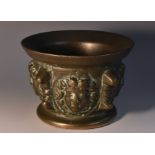 An Italian bronze mortar, flared bowl boldly cast in high relief with Medusa masks, lug handles,