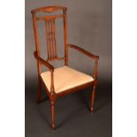 An Edwardian mahogany armchair, shaped cresting rail above a pierced splat, outswept scroll arms,