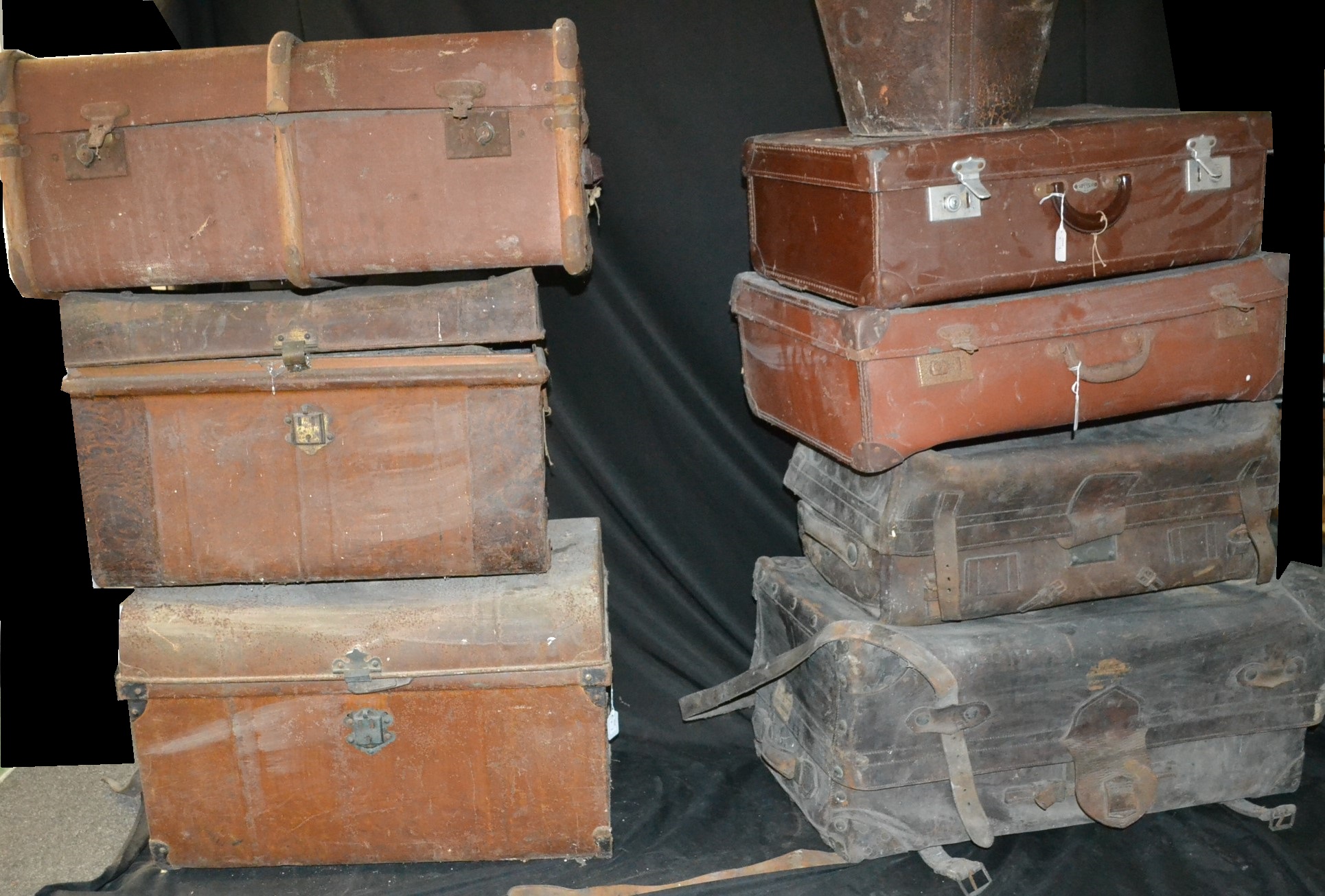 A large brown leather travelling trunk, early 20th century; other similar vintage luggage,