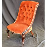 A Victorian nursing chair burnt ochre button backed upholstery, shaped and carved legs,