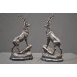 A pair of bronzed stags, after J Moigniez, each stood upon a rocky outcrop,