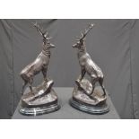 A pair of bronze stags, after J Moigniez, each stood upon a rocky outcrop,