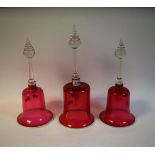 A pair of 19th century cranberry glass bells, white rims, clear glass handles, 32cm high; another,