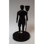 A dark patinated figural candlestick,