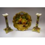 A pair of Coalport table candlesticks, painted by D Pass, signed, decorated with ripe blackberries,