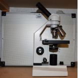 A Konus Academy 5304 monocular microscope, cased; slide specimens,