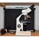 A Zenith BM-100FL Binocular College Microscope, cased; slide specimens,