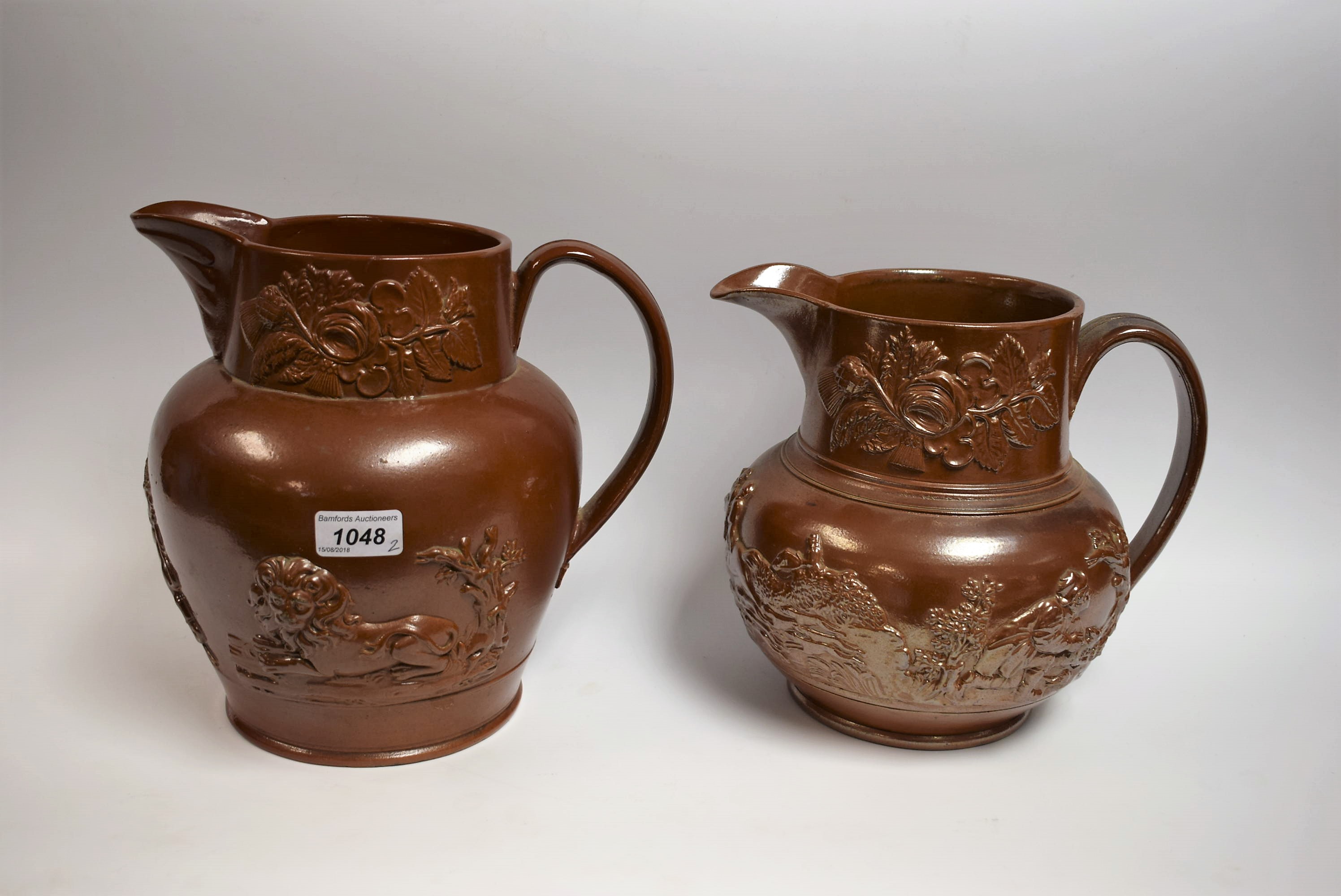 A 19th century Brampton brown salt glazed stoneware jug, in relief with crest flanked by lions,