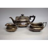 A George V silver three piece half fluted boat shaped tea service, comprising teapot,