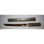 A Japanese style dagger, silver coloured scabbard with erotic scenes,